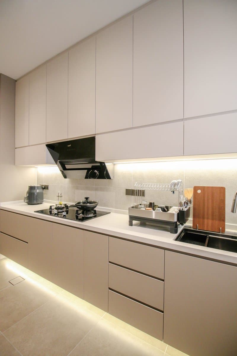 Custom kitchen cabinet by Mi Kuang — clean white design with LED under-cabinet lighting